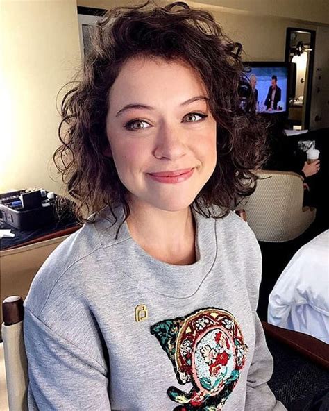 A Woman Sitting At A Table With A Plate Of Food In Front Of Her And Smiling