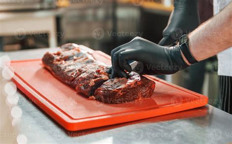 Close up view of slicing the meat. Professional chef preparing food in ...