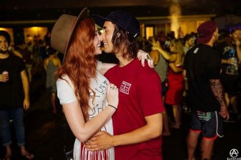 A Man And Woman Sharing A Kiss In Front Of A Crowd