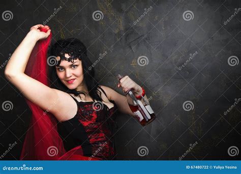 Happy Beautiful Brunette Woman In Corset And Long Hair With Bottle Of Red Wine Stock Photo