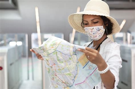 Retrato de una mujer morena consultando un mapa turístico Foto Premium