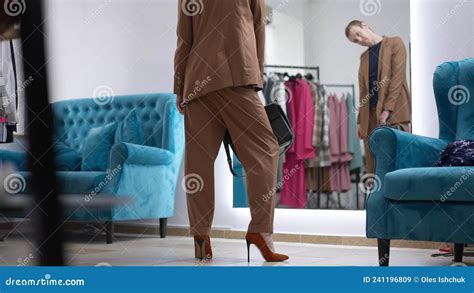 Gay Man In Elegant Suit And High Heels Walking With Handbag To Mirror Admiring Reflection