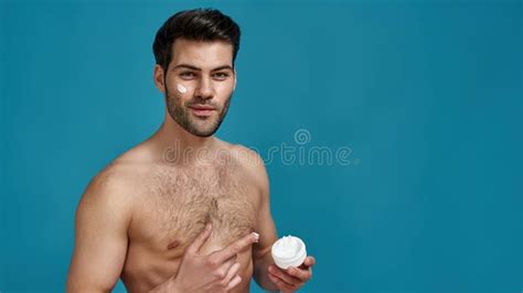 Studio Shot Of Brunette Man Advertising Pointing At White Jar Of