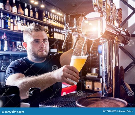 Bartender Pouring Draft Beer At Glasses In The Bar Restaurant Stock