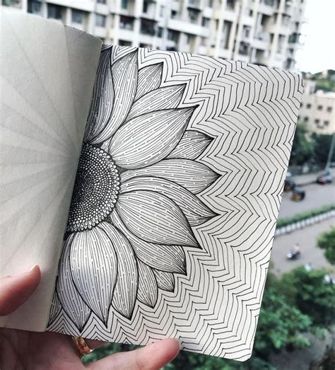 A Person Holding Up A Book With A Sunflower Drawn On The Front And Back