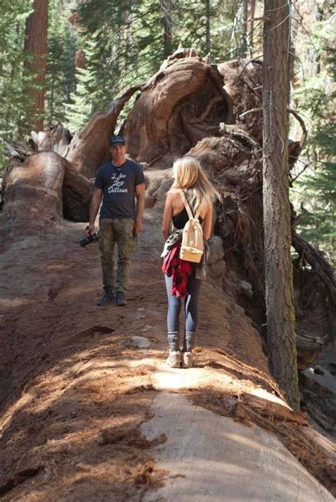 Two People Walking On A Trail In The Woods