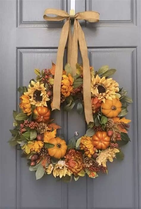 A Wreath With Sunflowers Pumpkins And Leaves Is Hanging On The Front Door