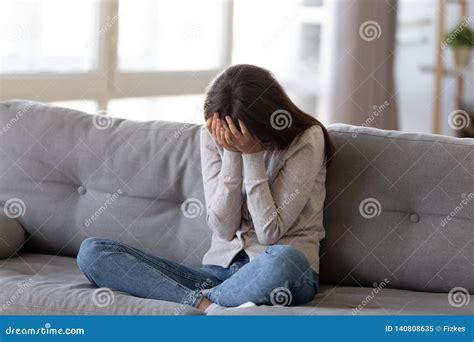 Depressed Young Woman Covering Face By Hands Crying Alone At Home