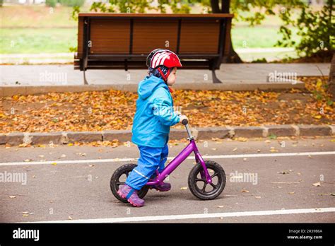 Niño de tres años está montando en bicicleta en equilibrio el ciclo vía