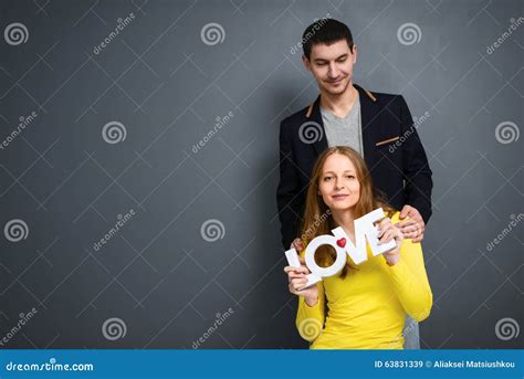 Beautiful Smiling Couple Holding Word Love Together On Gray