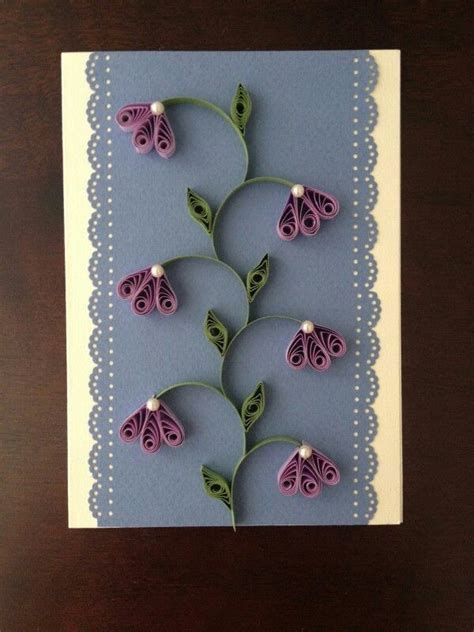 A Card With Some Flowers On It And Green Leaves Attached To The Back Of It