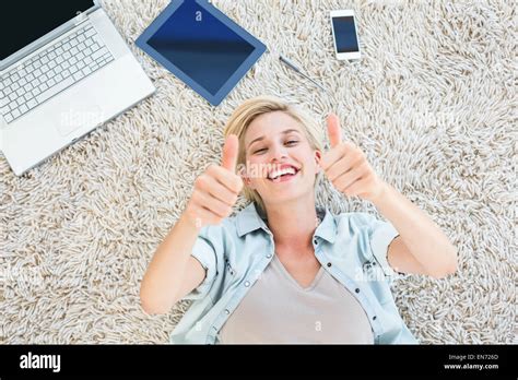 Pretty Blonde Woman Lying On The Floor And Smiling At The Camera Thumbs Up Stock Photo Alamy