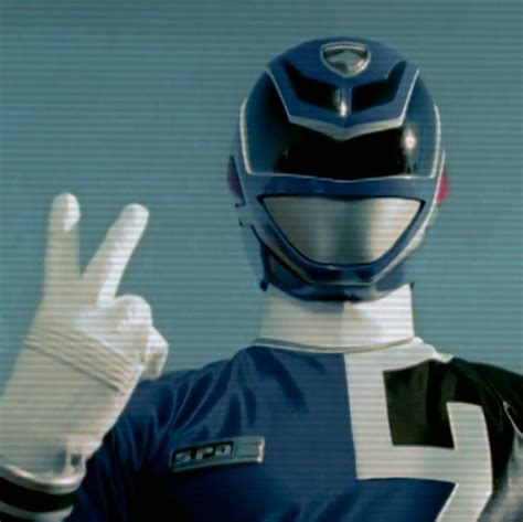 A Man In A Blue And White Suit Making The Peace Sign With His Hand