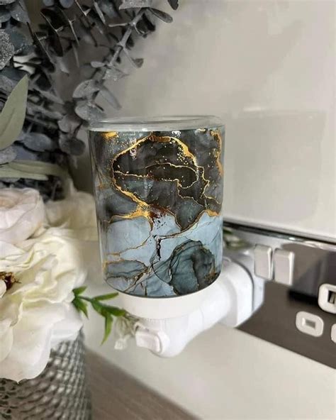 A Marbled Glass Candle Holder Sitting On Top Of A Counter Next To White