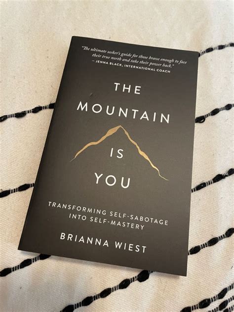 The Mountain Is You Book Sitting On Top Of A Bed With Black And White