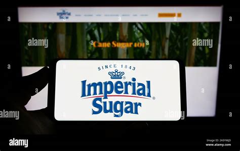 Person Holding Smartphone With Logo Of US Sugar Producer Imperial Sugar