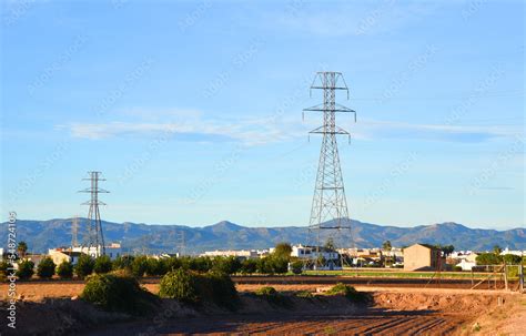 High Voltage Electricity Pylons And Transmission Power Lines In Farm