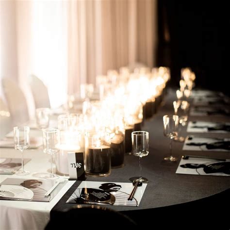 A Long Table Is Set With Wine Glasses And Candles