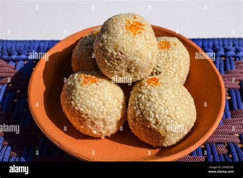 Makar Sankranti special food Tilgul ladoo recipe. white sesame seeds coated with jaggery sugar ...