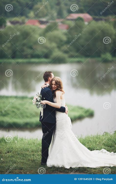 Beautifull Wedding Couple Kissing And Embracing Near Lake With Island