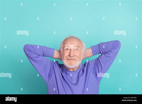 Photo Of Minded Satisfied Man Arms Behind Head Look Interested Up Above Empty Space Isolated On