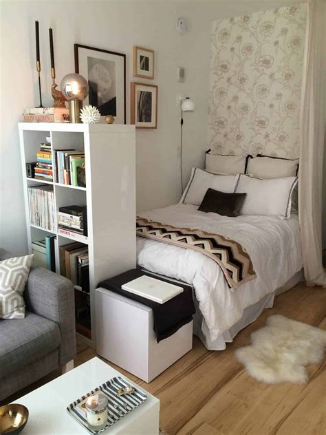 A Small Bedroom With A Bed Couch And Bookcase In The Middle Of It