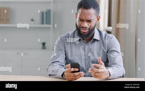 Stressed Disappointed African American Ethnic Bearded Man With Mobile