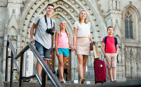 Familia Viajera De Cuatro Paseos Con Equipaje Por La Calle Europea De