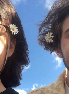 Two People With Flowers In Their Hair Looking Up At The Sky And One