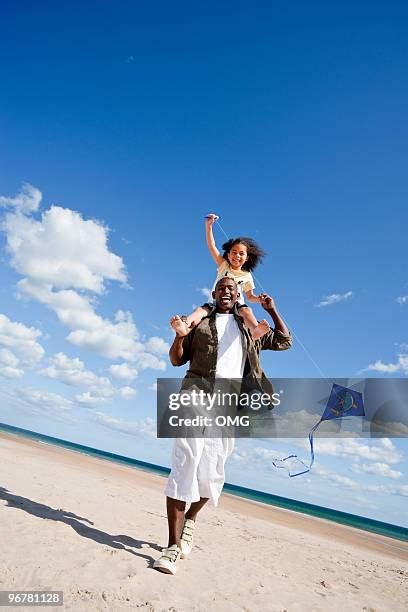 Black Father Carrying Daughter On Shoulders At Beach Photos And Premium