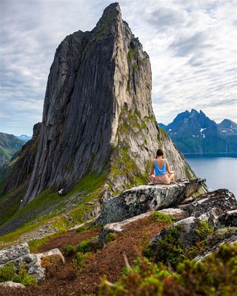 Una hermosa niña se sienta en las rocas disfrutando de la vista de la