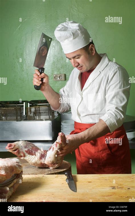 A Butcher Chopping Meat With A Cleaver Stock Photo Alamy