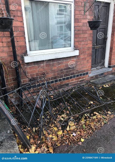 A Damaged Front Yard Black Iron Fence at a Terrace House Broken after