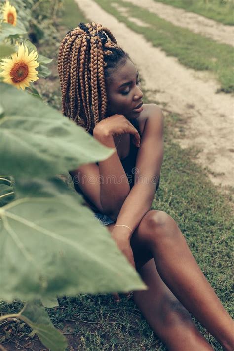 African American Girl In A Field Of Yellow Flowers At Sunset Stock