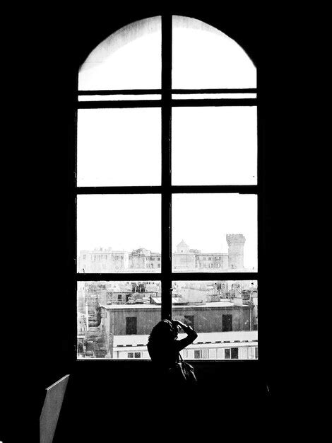 Vista Trasera De La Silueta De Una Mujer De Pie Junto A La Ventana En