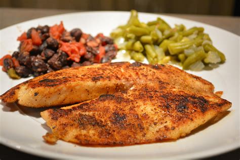 A White Plate Topped With Chicken Beans And Green Beans Next To A Side Dish