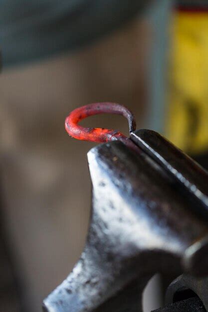 Premium Photo Blacksmith Bending Hot Iron On The Anvil