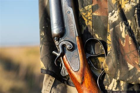 Premium Photo Mature Man Hunter With Gun While Walking On Field
