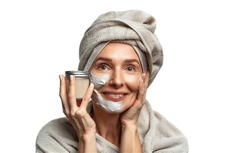 Une Femme Blanche Mature Et Joyeuse S Occupe De Sa Peau En Souriant En Appliquant De La Crème