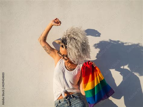 Mujer Joven Con Tatuajes Sujetando Un Bolso Con La Bandera Del Orgullo Gay Stock Photo Adobe Stock