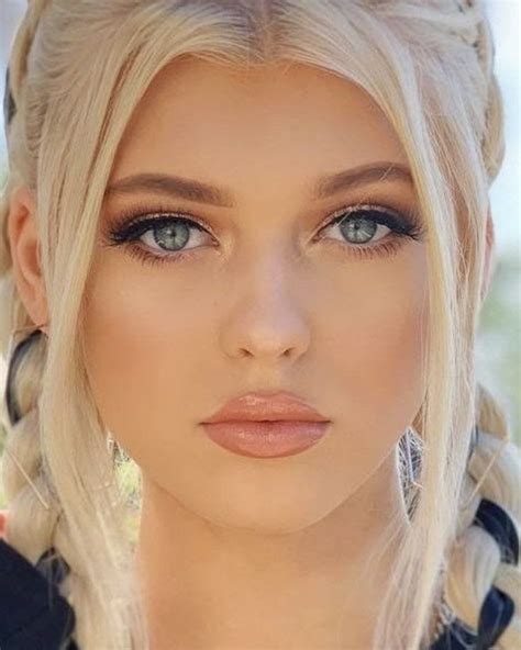 A Woman With Blonde Hair And Braids On Her Head Is Looking At The Camera