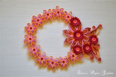 An Orange And Pink Brooch With Flowers On It S Side Sitting On A White