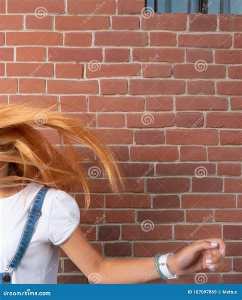 Blond Lady Dancing In Dront Of The Brick Wall And We Can See Her Flying