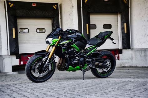 A Green And Black Motorcycle Parked In Front Of Two Garage Doors