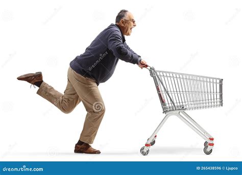 Excited Mature Man Running With An Empty Shopping Cart Stock Photo