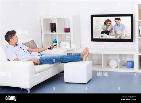 Mature Man Sitting On Couch Watching Television Stock Photo Alamy