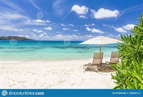 Two Beach Chairs And White Umbrella On Idyllic Tropical Sandy Beach