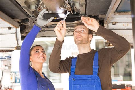 Dos Mec Nicos Que Reparan Un Coche En La Elevaci N Hidr Ulica Imagen De