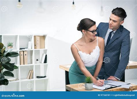 Young Businessman Looking At Seductive Businesswoman Working In Office