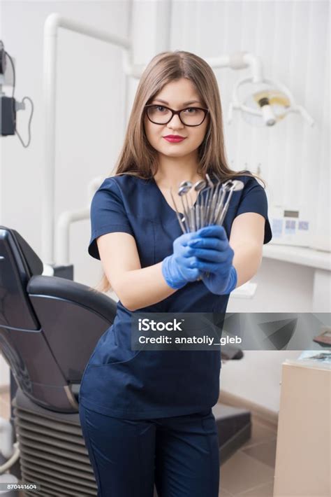 Portrait Of Attractive Female Dentist Holding Dental Tools At The